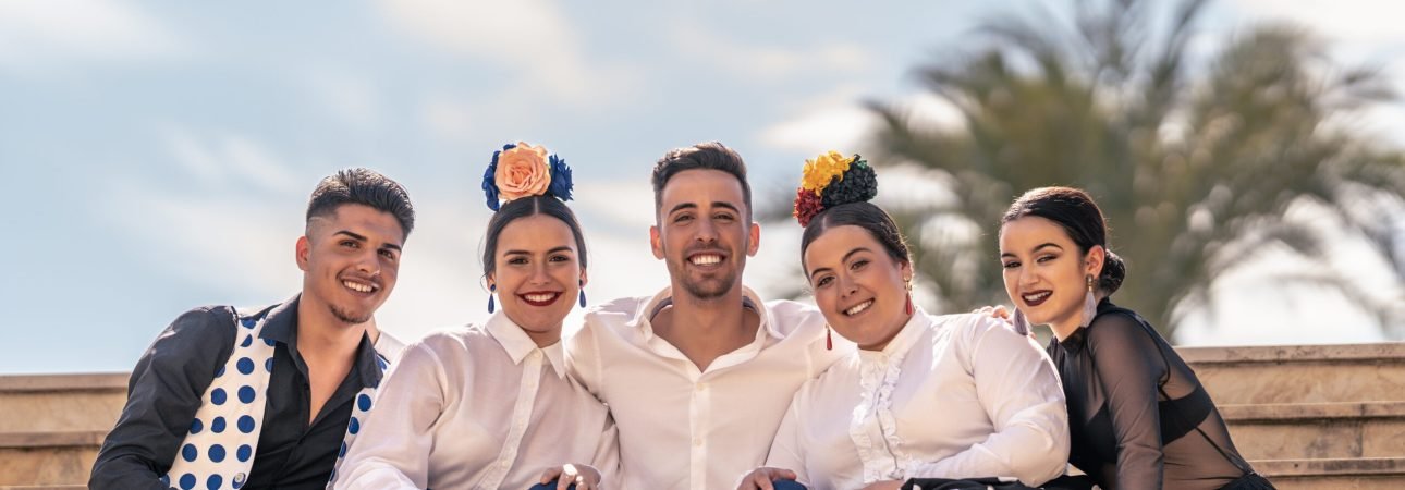 Medium full shot of a portrait of a flamenco teacher with his pupils seated on some steps